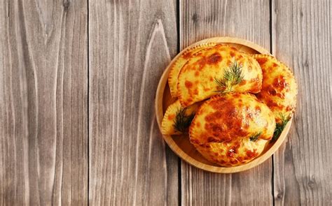 variedad de empanadas veganas recién horneadas sobre una mesa de madera