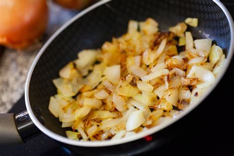 Detalle de cebolla caramelizándose en una sartén con tonos dorados y melosos