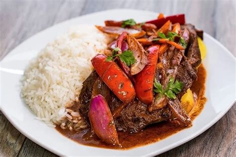 Bife de hígado encebollado servido con arroz blanco y ensalada