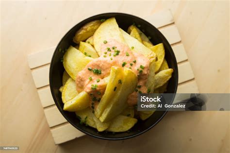 Patatas cortadas y sazonadas en un bol