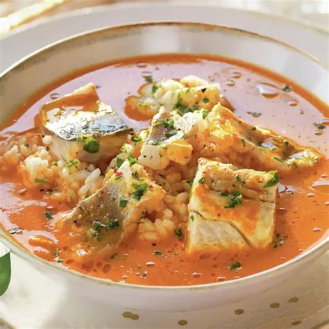Plato de sopa de pescado con arroz y gambas servido caliente