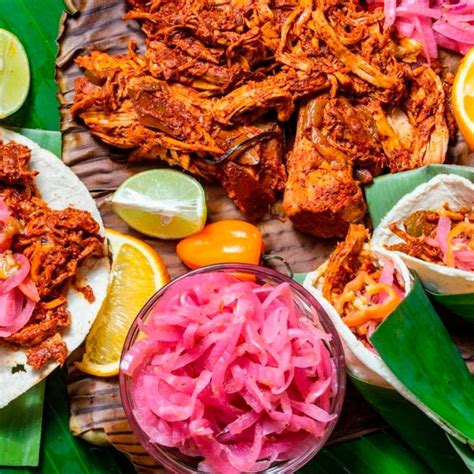 Cochinita pibil servida con tortillas y cebolla encurtida