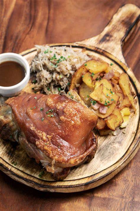 Plato servido de pernil con puré y ensalada