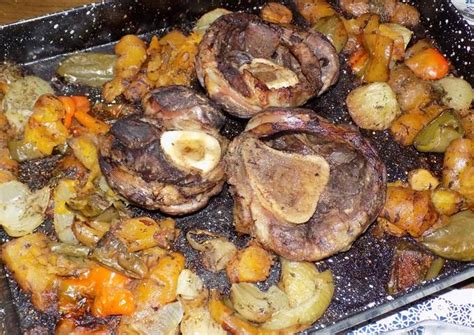 Bandeja de horno con osobuco y verduras listas para hornear