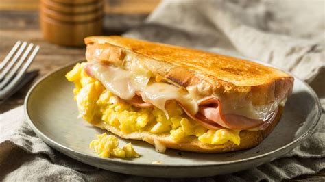 Sándwich de huevo estrellado con panceta y queso servido con mate