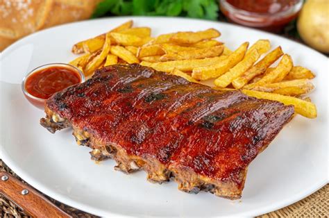 Plato de costillas de cerdo servido con guarniciones