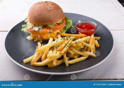 Hamburguesa casera servida con patatas fritas y salsa
