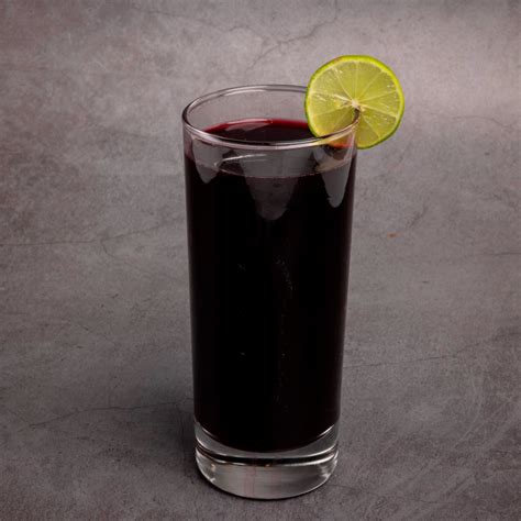 Chicha morada en un vaso con hielo y rodajas de limón