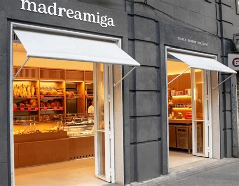 Fachada de una tienda Madreamiga con clientes en la entrada