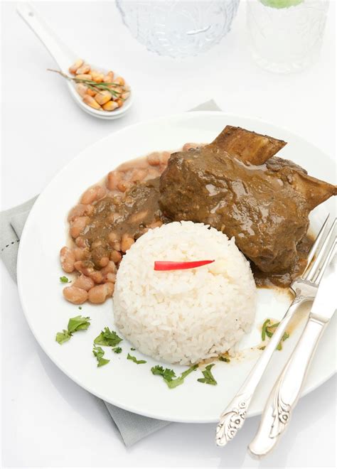 Seco de asado de tira servido con arroz, frijoles y salsa criolla