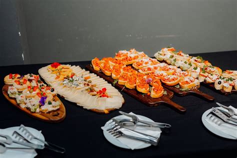Mesa decorada con sándwiches y otros bocadillos presentados de forma atractiva