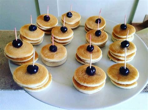 Mini panqueques decorados con crema y fresas simulando gorros de Papá Noel