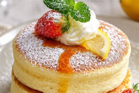 Panqueques soufflé japoneses altos y esponjosos servidos con mantequilla