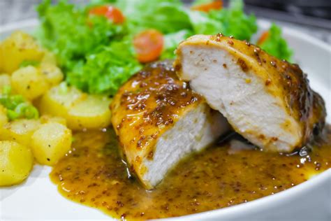 Plato servido de pollo a la mostaza con miel y patatas al horno