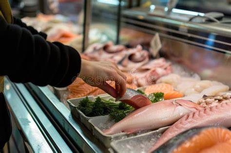 Persona eligiendo pescado en una pescadería