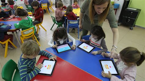 Niños interactuando con una tablet en un parque digital infantil