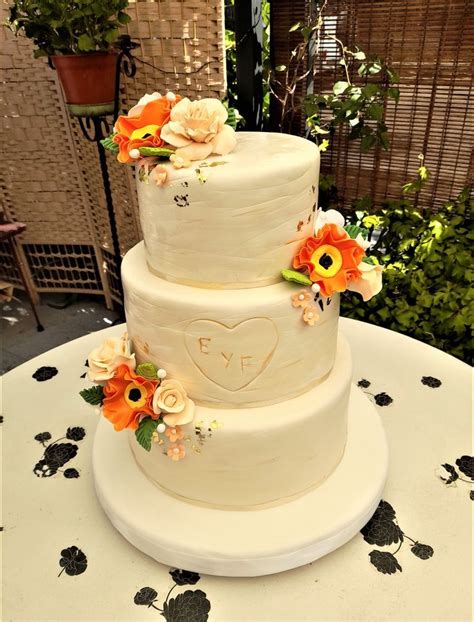 Torta de novios de varios pisos decorada con flores