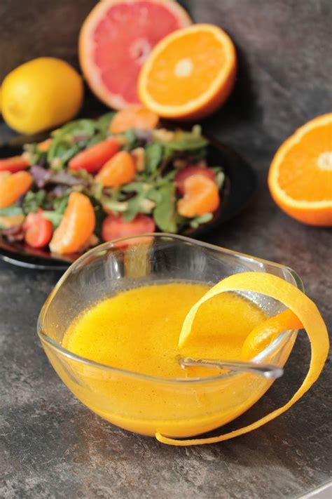 Botella de vinagreta casera de naranja con ingredientes cítricos