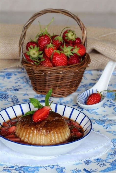 Flan y fresas en almíbar, junto a una taza de té