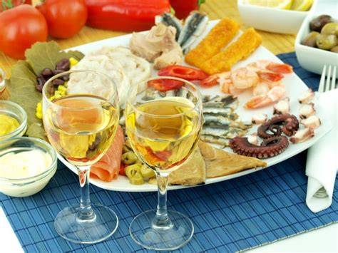 Copas de vino y cerveza con un plato de pasta