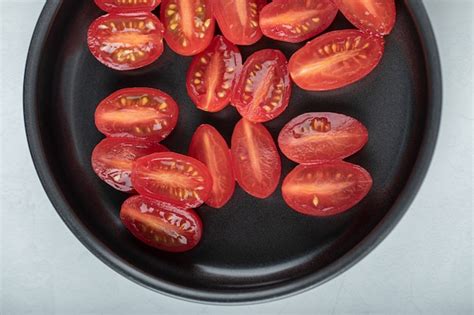 Tomates cherry cortados por la mitad en una bandeja de horno