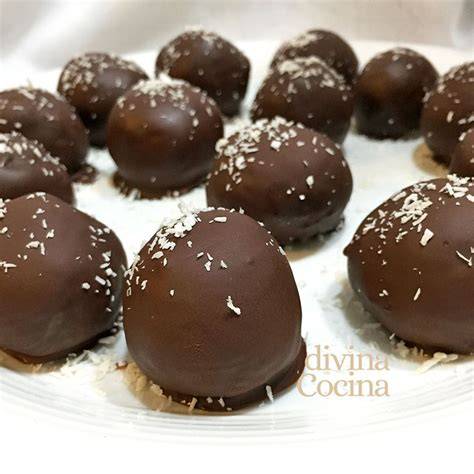 Bolitas de coco cubiertas de chocolate sobre papel de horno