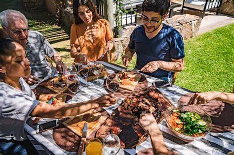 Familia disfrutando de una comida preparada en una tabla de asado Orbegozo