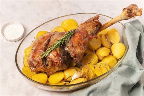 Cordero asado dorado y jugoso servido con patatas