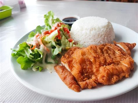 Plato de pollo frito chino con arroz y ensalada