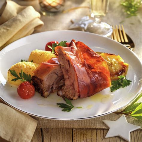 Cochinillo asado acompañado de patatas y espárragos
