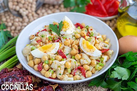 Plato de ensalada de garbanzos con pimientos asados y huevo duro sobre una mesa rústica