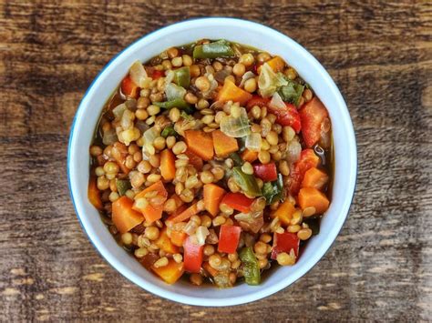 Plato humeante de guiso de lentejas con verduras frescas