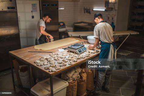 Panadero artesanal trabajando una gran masa de pan