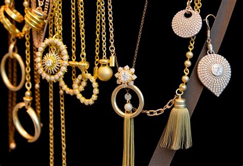 Detalle de accesorios en tonos dorados junto a una prenda en amarillo mantequilla