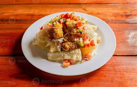 Plato de carnita frita servido con yuca y ensalada
