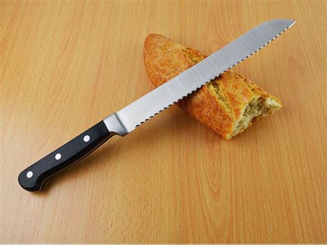 Cuchillo de sierra cortando una hogaza de pan artesanal