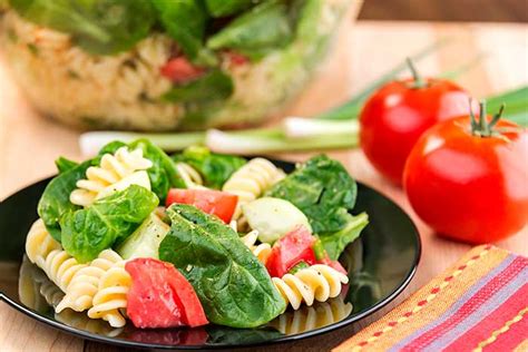 Ensalada de pasta con margaritas de tomate y espinacas