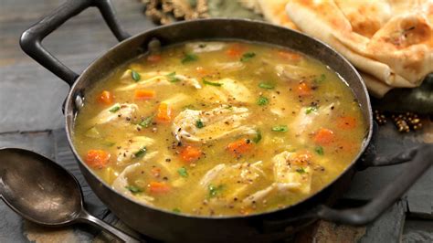 Sopa de pollo casera humeante en un tazón tradicional
