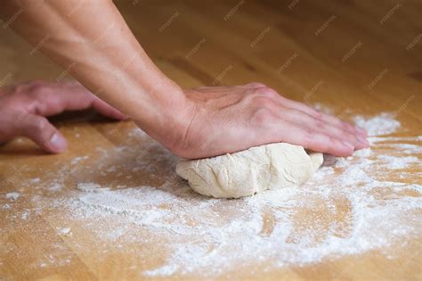 Persona amasando pasta a mano sobre una superficie de madera