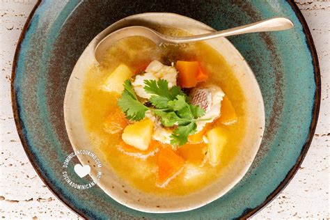 Plato de sopa de cabeza de pescado servido caliente con guarniciones