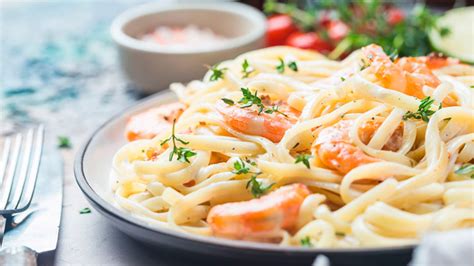 Pasta con camarones servida con queso parmesano