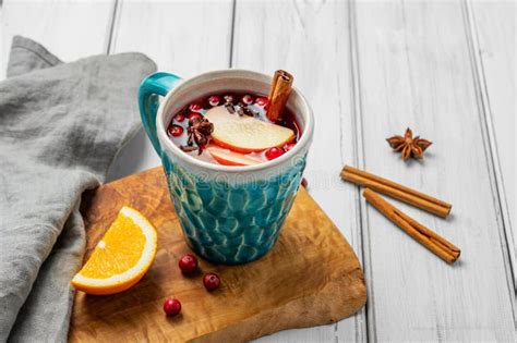 Vino caliente en una taza con especias y rodajas de naranja