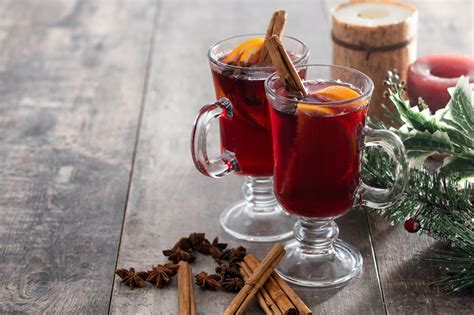 Mesa navideña con tazas de vino caliente y dulces