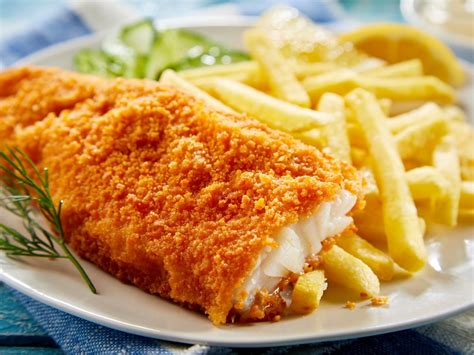 Pescado frito servido con patatas fritas y ensalada de col