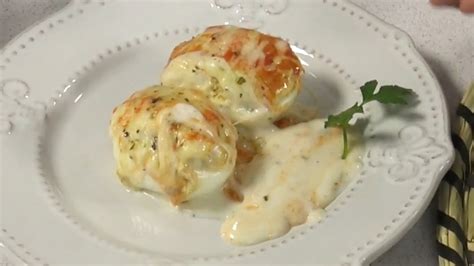 Huevos rellenos cubiertos con bechamel y queso listos para hornear