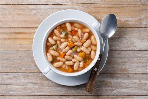 Plato de frijoles blancos guisados con vegetales frescos