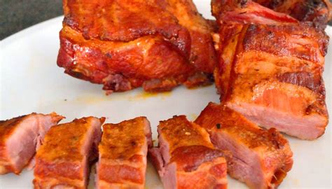 Costillas de cerdo adobadas sobre papas en bandeja de horno