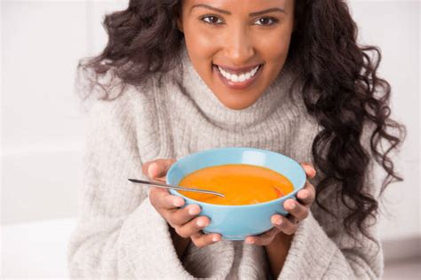 Mujer comiendo sopa caliente en invierno