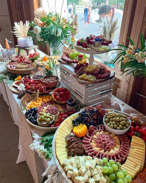 Mesa con variedad de aperitivos y pollos asados para llevar