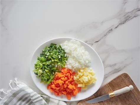 Ingredientes frescos como camarones, pescado y verduras picadas